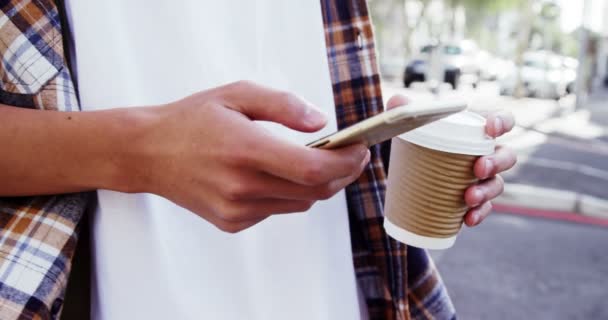 Mann schreibt SMS und trinkt Kaffee — Stockvideo