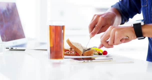 Mann isst Mittagessen mit Getränk im Büro — Stockvideo