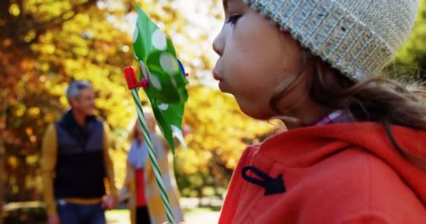 Girl blowing toy with parents — Stock Video