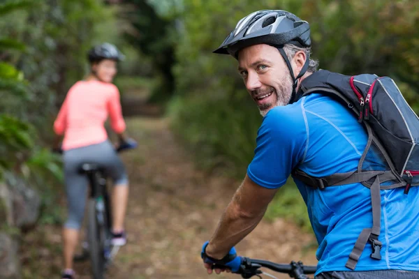 Athletic couple cycling in forest — Stock Photo, Image