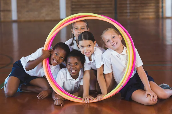 Miúdos da escola a olhar através do arco de hula — Fotografia de Stock