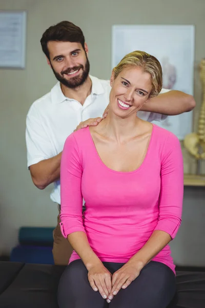 Fisioterapeuta masculino dando masaje en el cuello a una paciente femenina —  Fotos de Stock