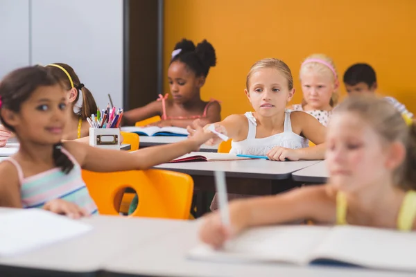 Écolière donner chit à son amis dans salle de classe — Photo