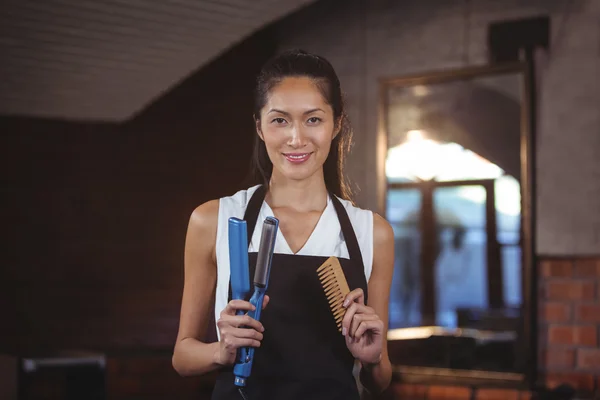 Female hairdresser holding straightener machine — Stock Photo, Image