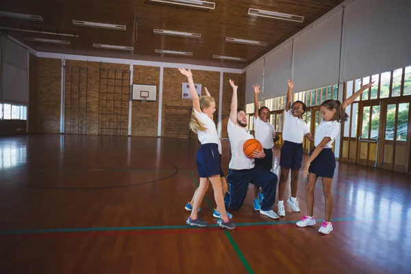 Spor öğretmeni ve okul çocuklar oynarken — Stok fotoğraf