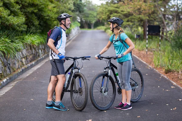 Pareja atlética de pie con bicicleta de montaña —  Fotos de Stock