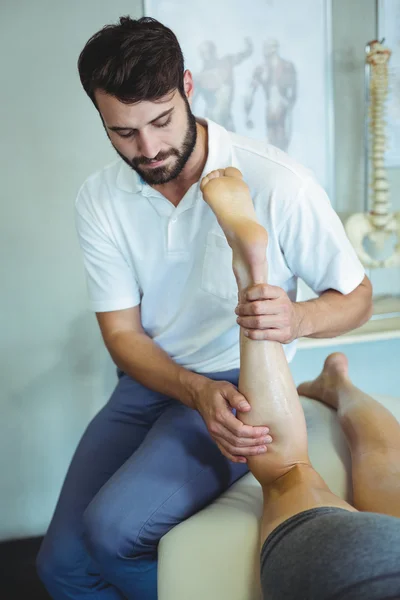 Sioterapeuta dando massagem nas pernas para uma mulher — Fotografia de Stock