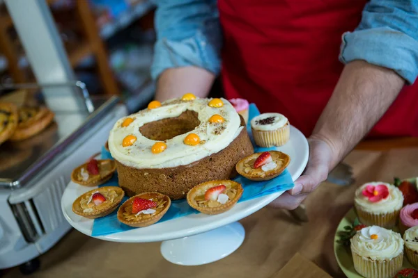 Anställda som innehar en bricka med desserter — Stockfoto