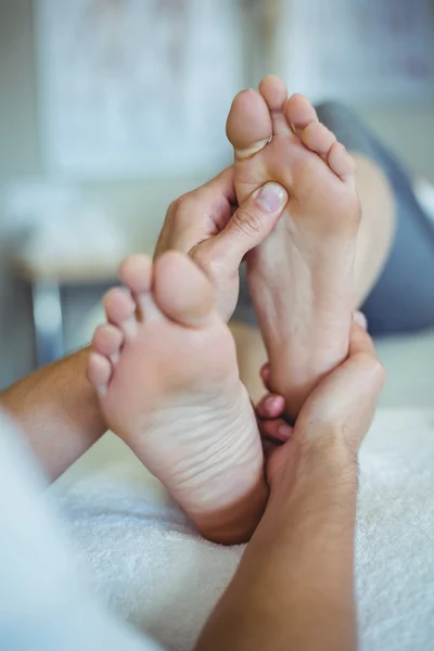 Φυσιοθεραπευτής δίνοντας τα πόδια μασάζ σε μια γυναίκα — Φωτογραφία Αρχείου