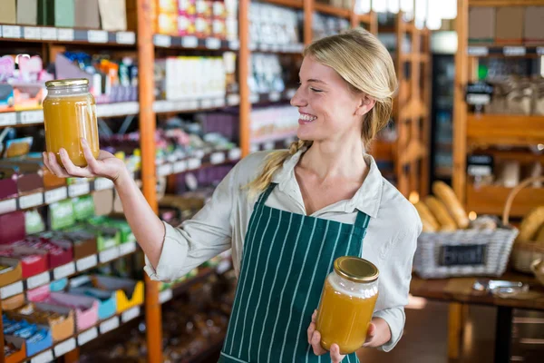 Női alkalmazottak gazdaság üvegek méz — Stock Fotó