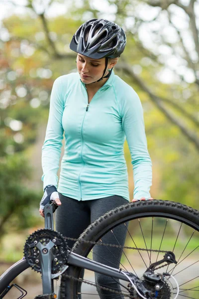 Fitte Frau repariert ihr Fahrrad — Stockfoto