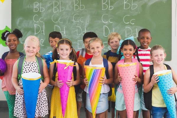 Bambini felici che tengono regali in classe — Foto Stock