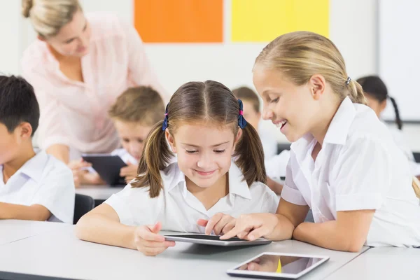 Crianças da escola usando tablet digital em sala de aula — Fotografia de Stock