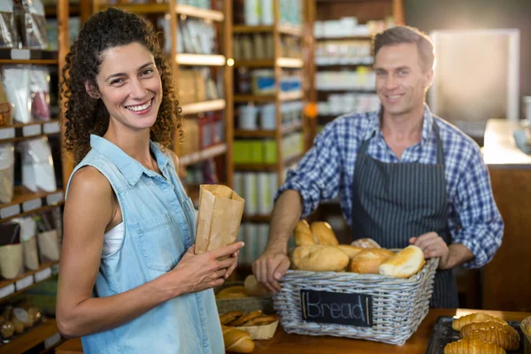 微笑的女人在面包店购买面包 — 图库照片