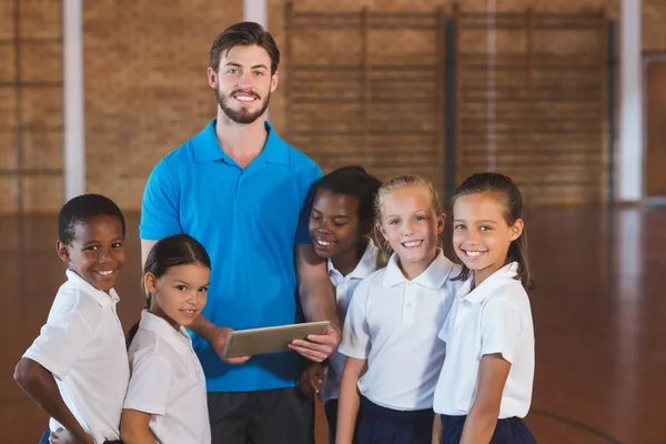 Sports teacher and school kids using digital tablet — Stock Photo, Image
