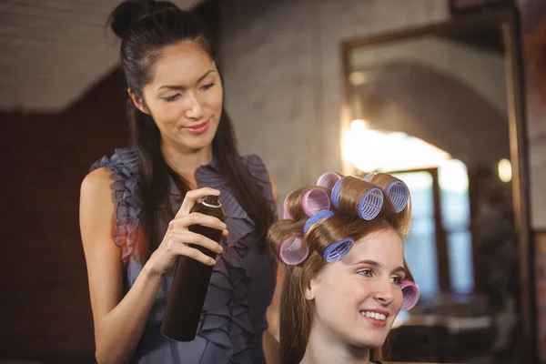 Female hairdresser styling customers hair — Stock Photo, Image