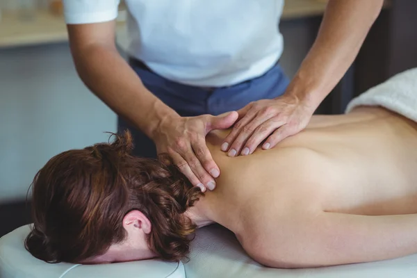 Physiotherapeutin gibt einer Frau Nackenmassage — Stockfoto