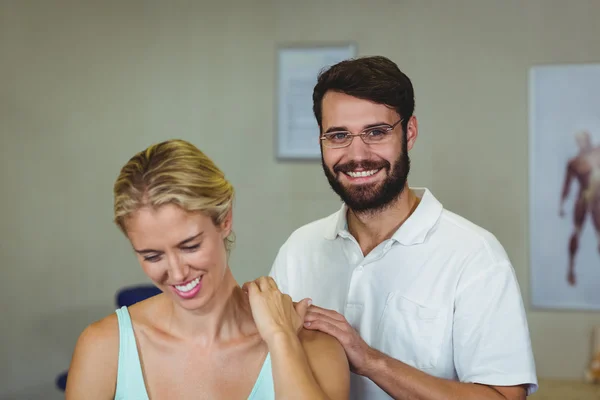 Manlig sjukgymnast ger nacke massage till kvinnlig patient — Stockfoto