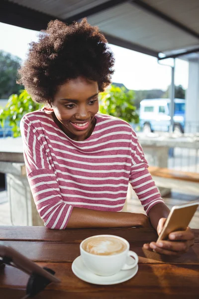 Frau benutzt Handy beim Kaffeetrinken — Stockfoto