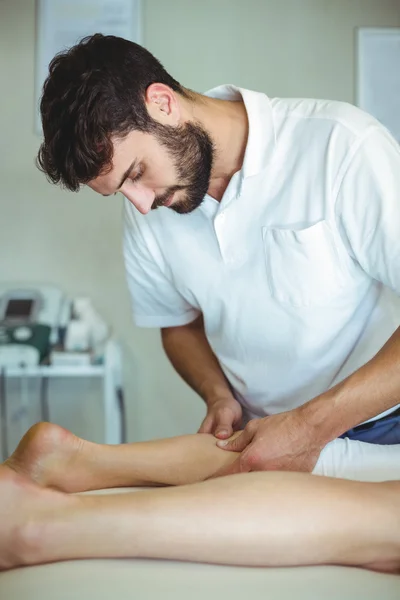 Физиотерапевт, делающий массаж ног женщине — стоковое фото