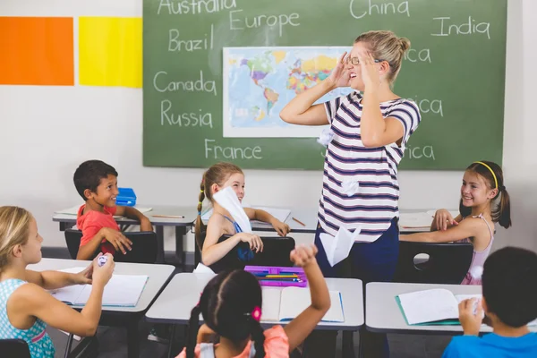 Skolbarnen kasta papper bollar på lärare — Stockfoto