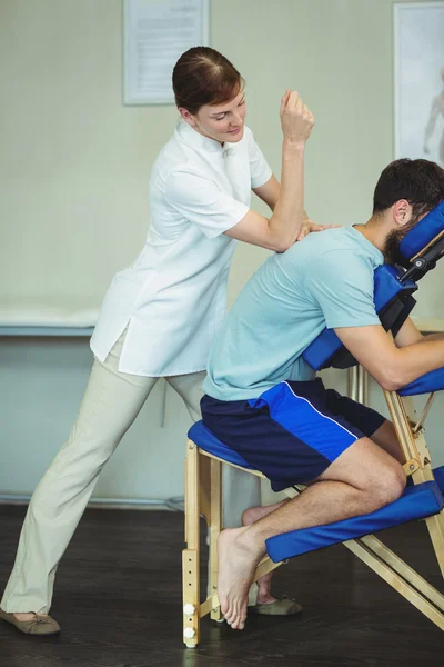 Physiotherapeut gibt einer Patientin Rückenmassage — Stockfoto