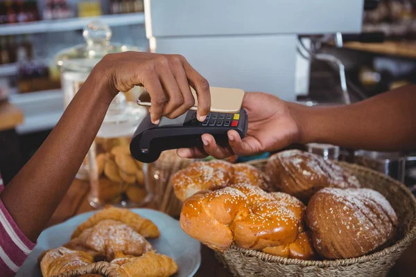 Женщина оплачивает счета через смартфон с использованием технологии NFC — стоковое фото