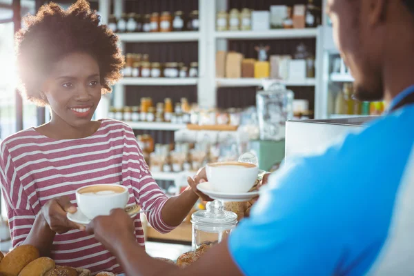 Servitören serverar en kaffe till en kvinna — Stockfoto