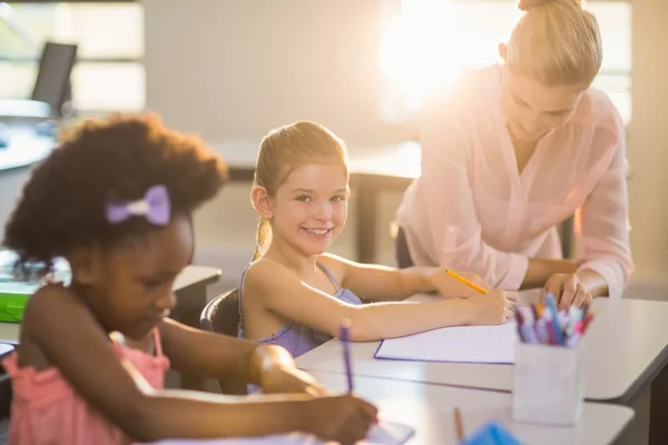 Kinderen helpen met hun huiswerk in klas leraar — Stockfoto