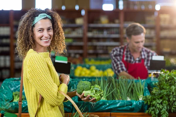 Donna sorridente acquistare verdure nella sezione biologica — Foto Stock