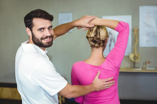 Fisioterapeuta masculino dando massagem no braço para paciente do sexo feminino — Fotografia de Stock