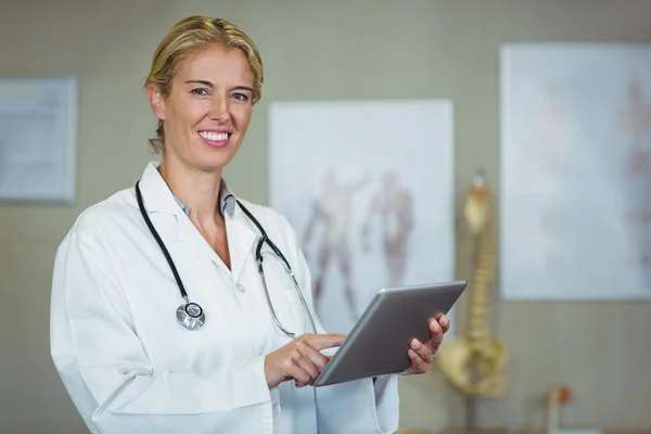 Fisioterapeuta femenina usando tableta digital en clínica —  Fotos de Stock