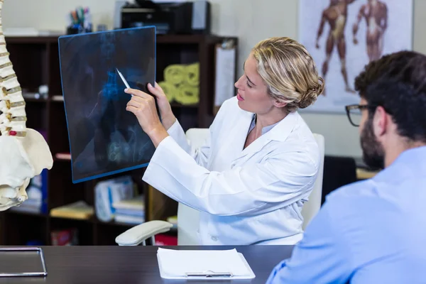 Physiotherapeut zeigt Röntgenbild einer Patientin — Stockfoto