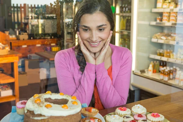 Mujer mirando la exhibición del postre —  Fotos de Stock