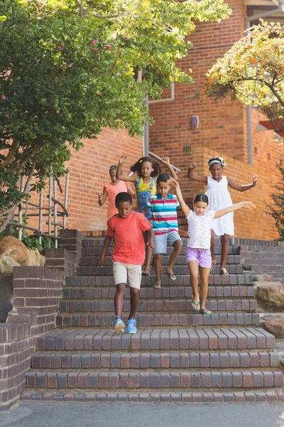 Group of kids getting down from staircase — Stock Photo, Image