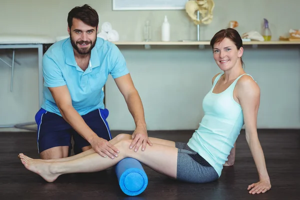 Physiotherapist doing leg therapy to a woman — Stock Photo, Image