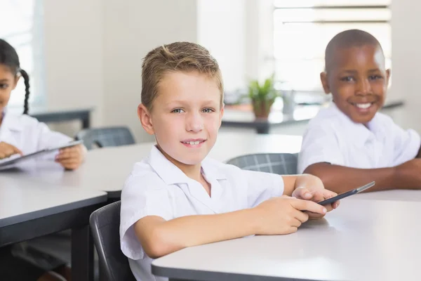 Retrato del niño de la escuela usando el teléfono móvil en el aula —  Fotos de Stock