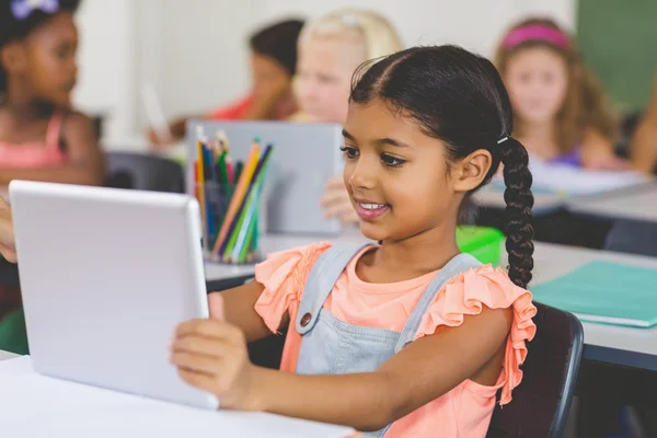 Schoolmeisje met behulp van de tablet in de klas — Stockfoto