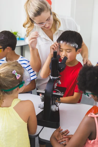 Lärare hjälpa barnen i laboratorium — Stockfoto