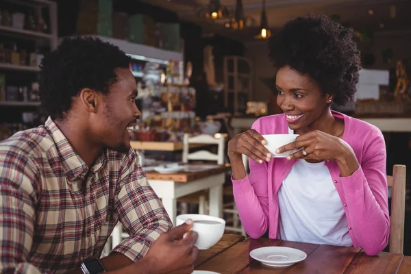 Pareja joven interactuando entre sí en la cafetería — Foto de Stock