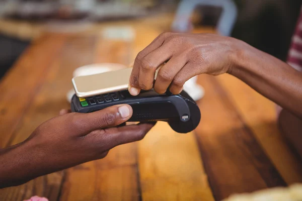 Woman paying bill through smartphone using nfc technology — Stock Photo, Image