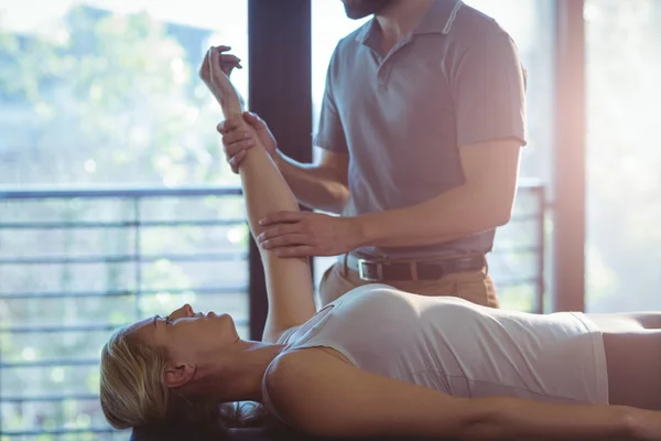 Žena přijímá ruku terapie cvičení od fyzioterapeuta — Stock fotografie