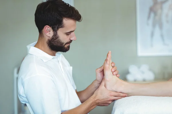 Физиотерапевт делает массаж ног женщине — стоковое фото