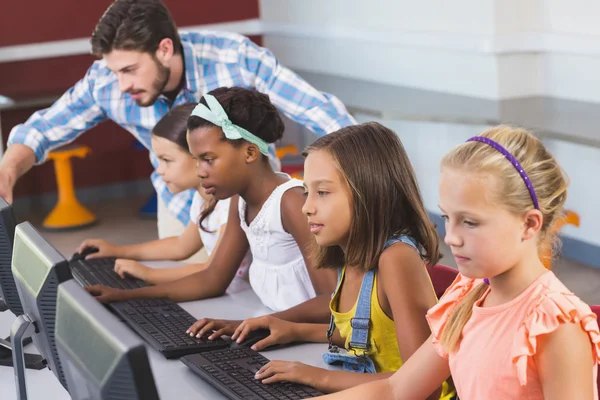 Lehrer unterstützt Schülerinnen beim Lernen von Computern — Stockfoto