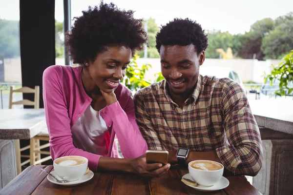 Молода пара використовує мобільний телефон в кафетерії — стокове фото