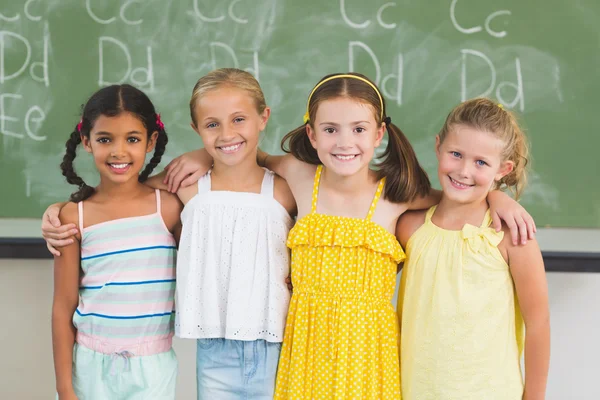 Usmiechniete dzieci stojąc z ramieniem w klasie — Zdjęcie stockowe