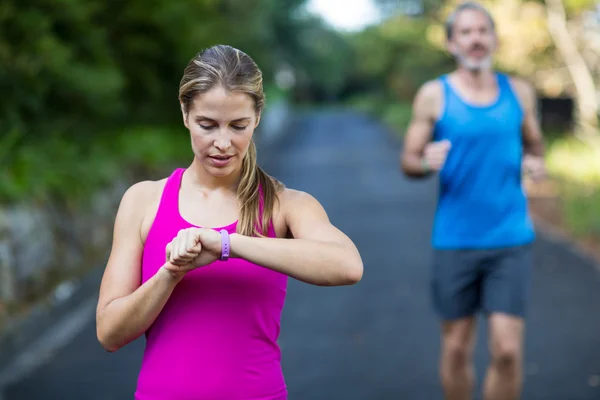 Ajuste mujer comprobar el tiempo en reloj de pulsera — Foto de Stock