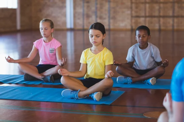 Bambini della scuola che meditano durante la lezione di yoga — Foto Stock