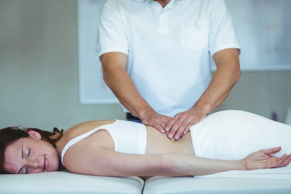 Physiotherapeutin gibt einer Frau Rückenmassage — Stockfoto