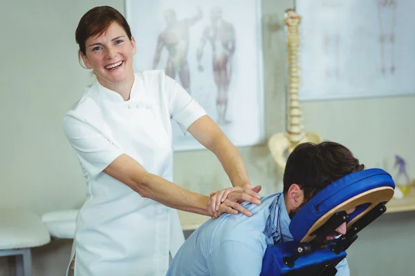 Fisioterapeuta dando masaje de espalda a un paciente —  Fotos de Stock
